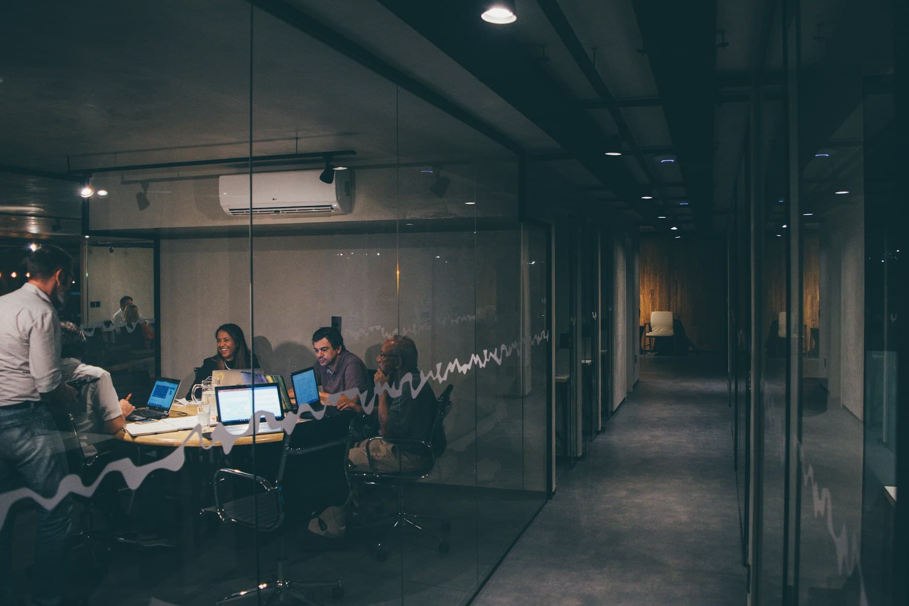 A collaborative team meeting around laptops in a modern office.